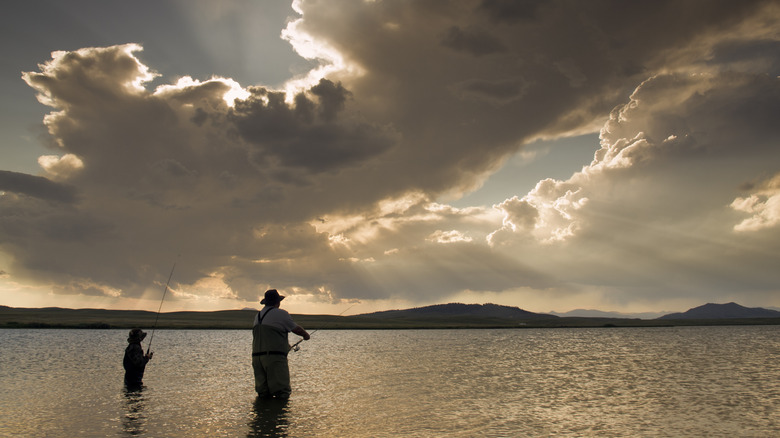 man and child fishing at sunset