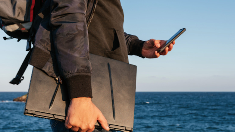 Person traveling with laptop and phone