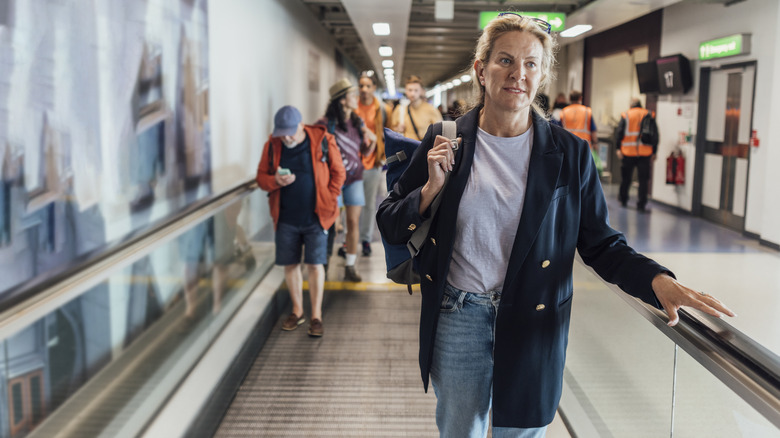 people on airport moving walkway