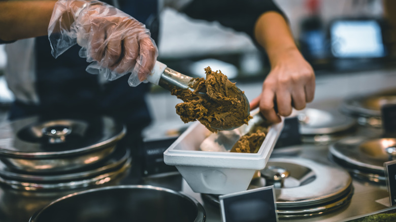 Server scooping gelato onto plate