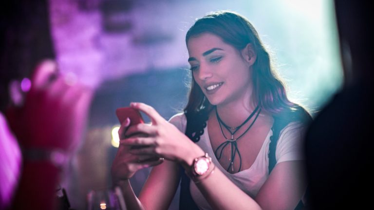 Woman in a bar texting