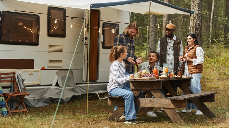 friends at picnic table in front of RV