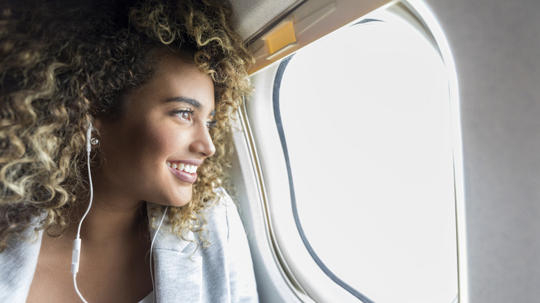 woman looking out plane window