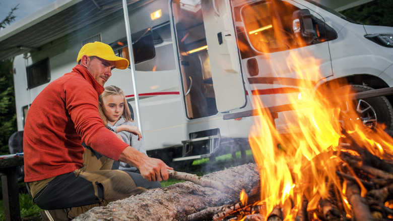 Family with RV building campfire