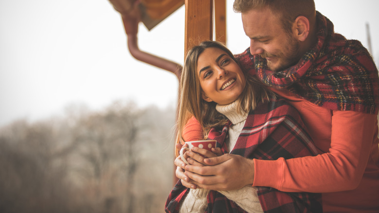 couple cuddling on cabin porch