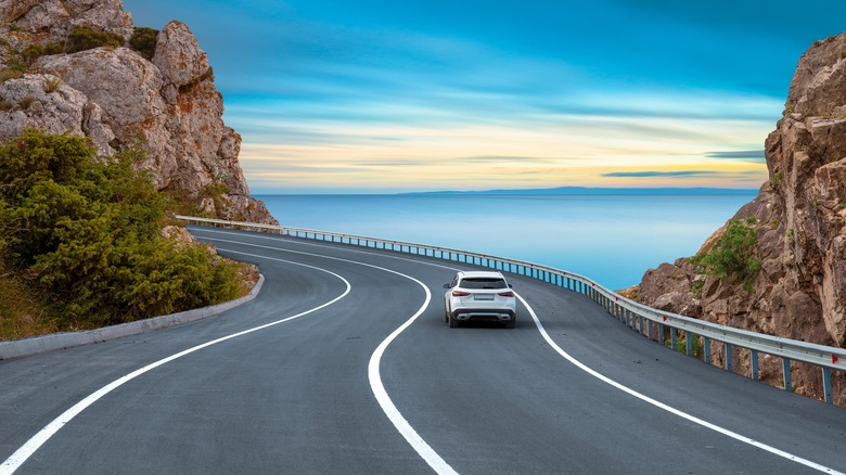 Car driving down coastal road