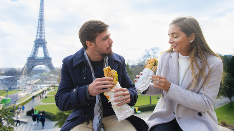 Couple eating baguettes in Paris